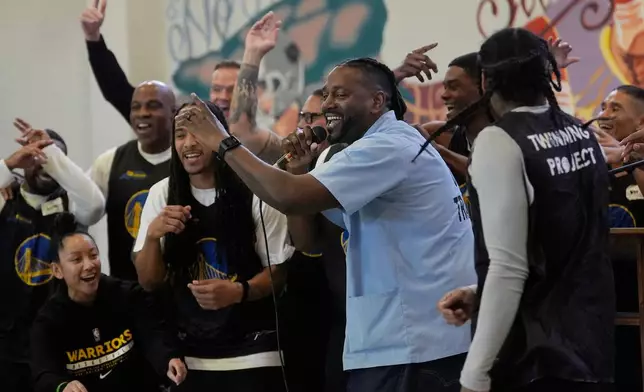 Ray Woodfork, a graduate of Twinning Project's collaboration with the NBA's Golden State Warriors and the California Department of Corrections and Rehabilitation's cohort 1, middle, performs a rap song in front of cohort 2 participants and Warriors Basketball Academy members at Solano State Prison in Vacaville, Calif., Tuesday, Feb. 11, 2025. (AP Photo/Jeff Chiu)