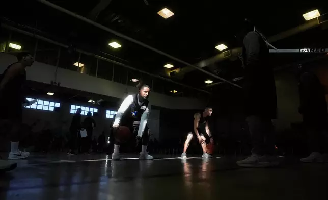 Anthony Silva, middle left, practices with Viet Kim Le as they and other Twinning Project cohort 2 participants perform basketball drills during the project's collaboration with the NBA's Golden State Warriors and the California Department of Corrections and Rehabilitation at Solano State Prison in Vacaville, Calif., Tuesday, Feb. 11, 2025. (AP Photo/Jeff Chiu)