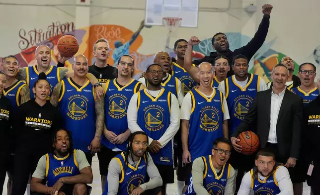 Former NBA basketball player Festus Ezeli, top right, celebrates with coaches and Twinning Project cohort 2 graduates during the project's collaboration with the Golden State Warriors and the California Department of Corrections and Rehabilitation at Solano State Prison in Vacaville, Calif., Tuesday, Feb. 11, 2025. (AP Photo/Jeff Chiu)