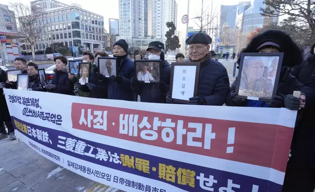 FILE - Family members of forced labor victims during the Japan's colonial period arrive at the Supreme Court in Seoul, South Korea, on Dec. 21, 2023. The sign reads "Mitsubishi Heavy Industries should compensate and apologize." (AP Photo/Ahn Young-joon, File)