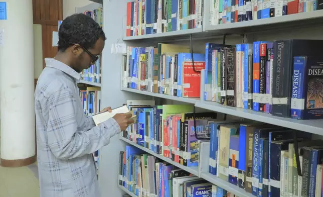 Yonas Nuguse, 21 years old, destined for Harvard University flicking through a book at Wemezeker National Library in Addis Ababa, Ethiopia Friday, May 30, 2025. (AP Photo/Amanuel Birhane)