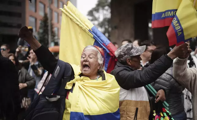 People march to the clinic where Colombian Senator Miguel Uribe Turbay is being treated after an assassination attempt, in Bogota, Colombia, Sunday, June 8, 2025. (AP Photo/Ivan Valencia)