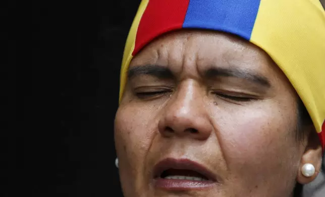 A woman prays outside the clinic where Colombian Senator Miguel Uribe Turbay is being treated after he was shot, in Bogota, Colombia, Sunday, June 8, 2025. (AP Photo/John Vizcaino)