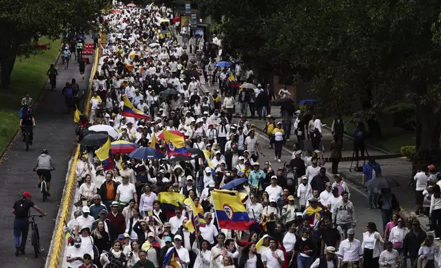 People march to the clinic where Colombian Senator Miguel Uribe Turbay is being treated after he was shot, in Bogota, Colombia, Sunday, June 8, 2025. (AP Photo/Ivan Valencia)