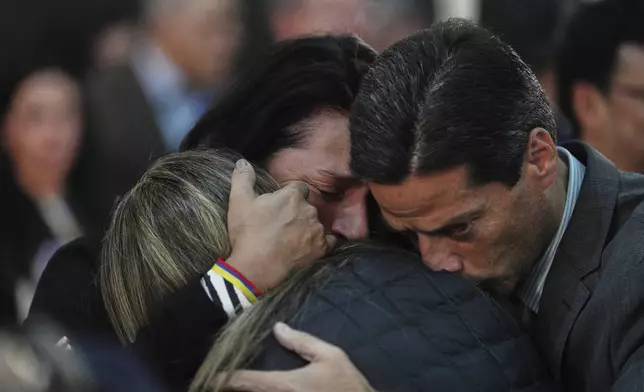 People embrace during a Mass to pray for Sen. Miguel Uribe Turbay's health, after he was shot at a political rally, in Bogota, Colombia, Monday, June 9, 2025. (AP Photo/Ivan Valencia)