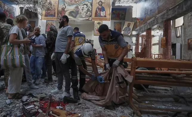 Syrian Civil Defence workers remove body remains inside Mar Elias church where a suicide bomber detonated himself in Dweil'a in the outskirts of Damascus, Syria, Sunday June 22, 2025. (AP Photo/Omar Sanadiki)