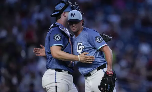 Washington Nationals catcher Riley Adams, left, and pitcher Kyle Finnegan celebrate after winning a baseball game against the Texas Rangers at Nationals Park, Friday, June 6, 2025, in Washington. (AP Photo/Jess Rapfogel)