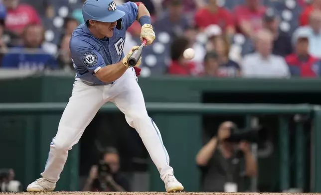 Washington Nationals' Jacob Young bunts for a single against the Texas Rangers during the second inning of a baseball game at Nationals Park, Friday, June 6, 2025, in Washington. (AP Photo/Jess Rapfogel)