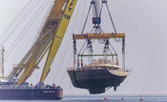 The hull of the superyacht Bayesian, which sank near Palermo, Sicily, on August 19, 2024, is pulled out of the sea off the village of Porticello to be taken to the nearby shipyard in Termini Imerese, Sunday, June 22, 2025. (AP Photo/Salvatore Cavalli)