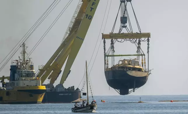The hull of the superyacht Bayesian, which sank near Palermo, Sicily, on August 19, 2024, is pulled out of the sea off the village of Porticello to be taken to the nearby shipyard in Termini Imerese, Sunday, June 22, 2025. (AP Photo/Salvatore Cavalli)