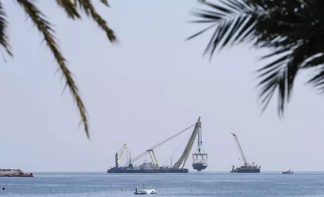 The hull of the superyacht Bayesian, which sank near Palermo, Sicily, on August 19, 2024, is pulled out of the sea off the village of Porticello to be taken to the nearby shipyard in Termini Imerese, Sunday, June 22, 2025. (AP Photo/Salvatore Cavalli)