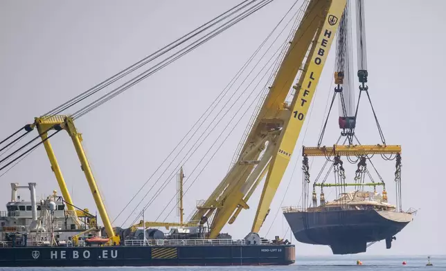 The hull of the superyacht Bayesian, which sank near Palermo, Sicily, on August 19, 2024, is pulled out of the sea off the village of Porticello to be taken to the nearby shipyard in Termini Imerese, Sunday, June 22, 2025. (AP Photo/Salvatore Cavalli)