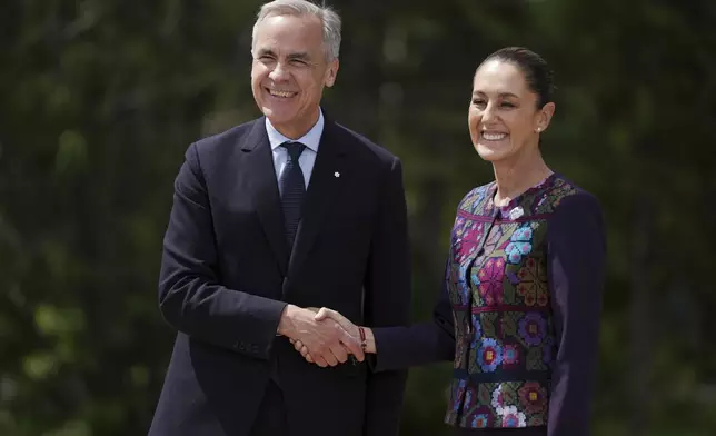 Canada's Prime Minister Mark Carney welcomes Mexican President Claudia Sheinbaum to the G7 Summit in Kananaskis, Alberta, Tuesday, June 17, 2025. (Darryl Dyck/The Canadian Press via AP)