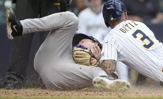 Milwaukee Brewers' Joey Ortiz (3) scores on a wild pitch past the tag of Colorado Rockies' Victor Vodnik during the 10th inning of a baseball game, Sunday, June 29, 2025, in Milwaukee. (AP Photo/Aaron Gash)