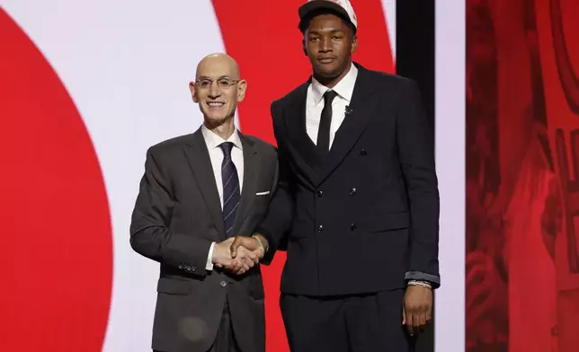 Derik Queen poses for a photo with NBA commissioner Adam Silver after being selected 13th by the Atlanta Hawks in the first round of the NBA basketball draft, Wednesday, June 25, 2025, in New York. (AP Photo/Adam Hunger)