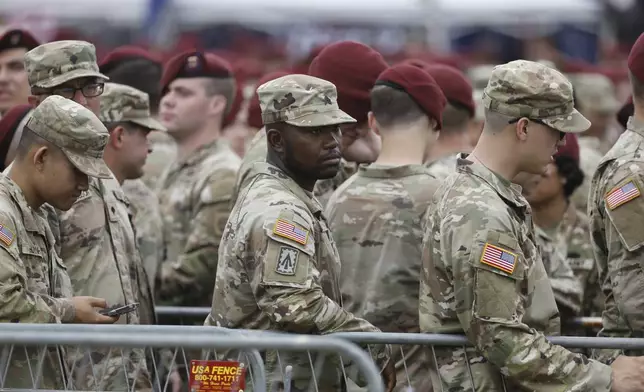 Soldiers at Fort Bragg line up to get into the grounds where later this afternoon President Donald Trump will be speaking in Fayetteville, N.C., Tuesday, June 10, 2025. (AP Photo/Karl DeBlaker)