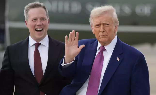 President Donald Trump waves as Secretary of the U.S. Army Daniel Driscoll watches at Pope Army Airfield at Fort Bragg, Tuesday, June 10, 2025, in Fort Bragg, N.C. (AP Photo/Alex Brandon)