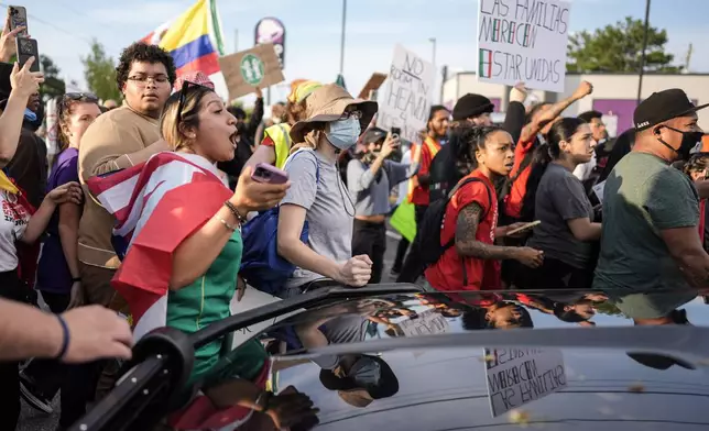 Protesters speak to authorities after the arrest of a man detained by police during an immigration demonstration, Tuesday, June 10, 2025, in Brookhaven, near Atlanta. (AP Photo/Mike Stewart)