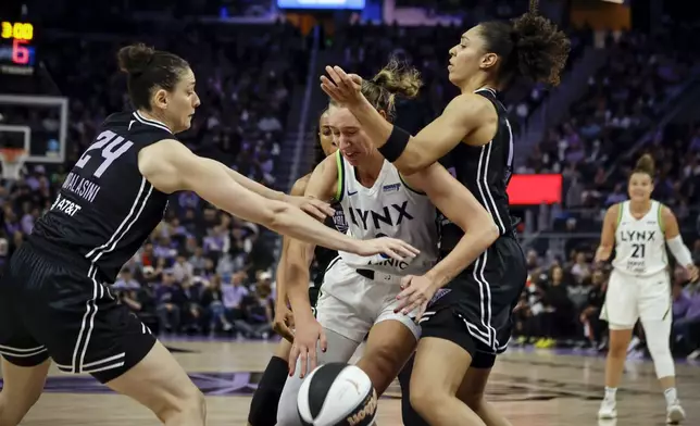 Minnesota Lynx's Alanna Smith, center, is defended by Golden State Valkyries' Cecilia Zandalasini (24) and Stephanie Talbot, right, in the first half of a WNBA basketball game in San Francisco, Sunday, June 1, 2025. (Carlos Avila Gonzalez/San Francisco Chronicle via AP)