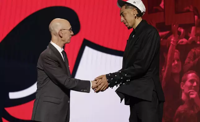 Noa Essengue greets NBA commissioner Adam Silver after being selected 12th by the Chicago Bulls in the first round of the NBA basketball draft, Wednesday, June 25, 2025, in New York. (AP Photo/Adam Hunger)