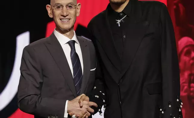Noa Essengue poses for a photo with NBA commissioner Adam Silver after being selected 12th by the Chicago Bulls in the first round of the NBA basketball draft, Wednesday, June 25, 2025, in New York. (AP Photo/Adam Hunger)