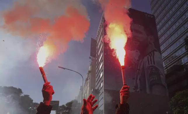 Supporters of Argentina's former President Cristina Fernandez hold flares as they protest in her defense after she began serving a six-year prison sentence under house arrest for corruption in Buenos Aires, Argentina, Wednesday, June 18, 2025. (AP Photo/Rodrigo Abd)