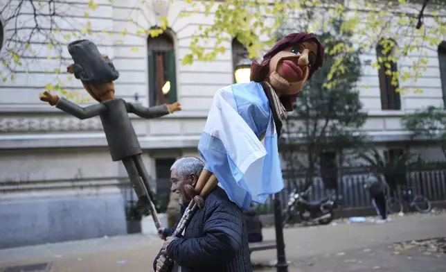 A supporter carries a puppet depicting Argentina's former President Cristina Fernandez after taking part in a protest in her defense after she began serving a six-year prison sentence under house arrest for corruption, in Buenos Aires, Argentina, Wednesday, June 18, 2025. (AP Photo/Rodrigo Abd)