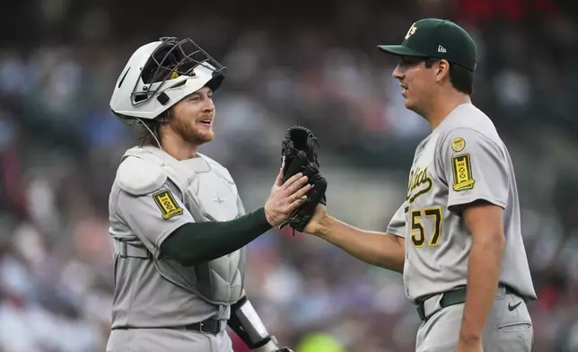 Athletics catcher Willie MacIver (65) and pitcher Jacob Lopez (57) react after the final out against the Detroit Tigers in the sixth inning during a baseball game, Wednesday, June 25, 2025, in Detroit. (AP Photo/Paul Sancya)