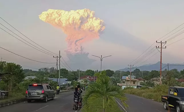 People watch as Mount Lewotobi Laki-Laki spews volcanic materials into the air during an eruption, in Maumere, Indonesia, Tuesday, June 17, 2025. (AP Photo)