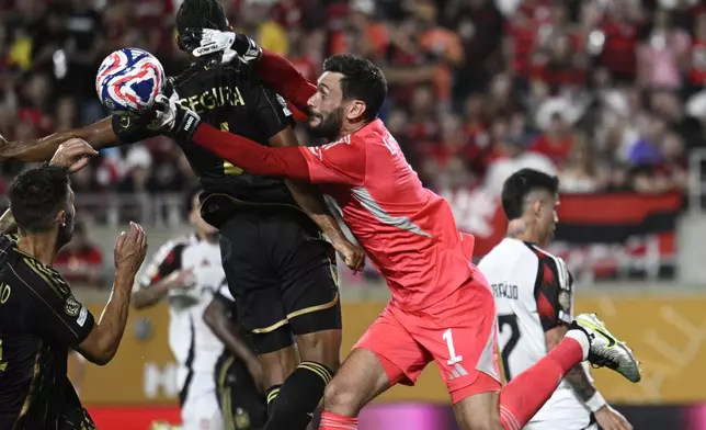 Los Angeles FC's Hugo Lloris, right, clears a ball next to his teammate Eddie Segura during the Club World Cup Group D soccer match between Los Angeles FC and Flamengo in Orlando, Fla., Tuesday, June 24, 2025. (AP Photo/Phelan Ebenhack)