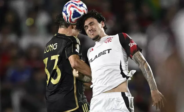 Flamengo's Pedro, right, and Los Angeles FC's Aaron Long compete for the ball during the Club World Cup Group D soccer match between Los Angeles FC and Flamengo in Orlando, Fla., Tuesday, June 24, 2025. (AP Photo/Phelan Ebenhack)