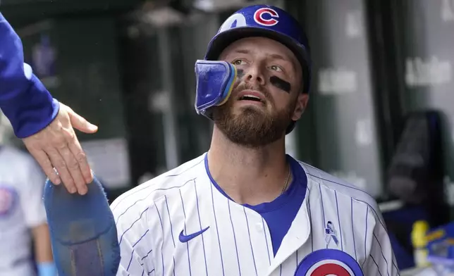 Chicago Cubs' Michael Busch is greeted in the dugout after scoring against the Pittsburgh Pirates during the first inning of a baseball game Sunday, June 15, 2025, in Chicago. (AP Photo/David Banks)