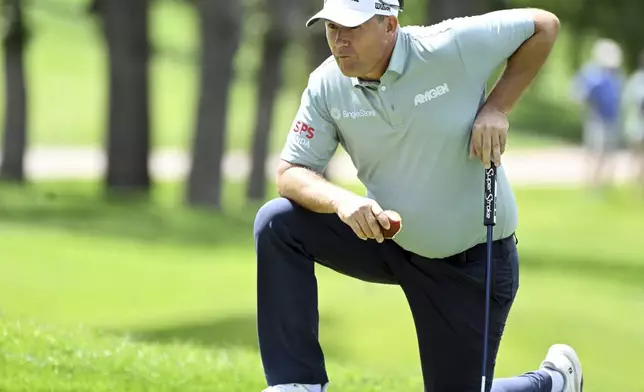 Padraig Harrington eats an apple while lining up a putt on the 10th hole on the first day at the U.S. Senior Open Championship at Broadmoor Golf Club in Colorado Springs, Colo., Thursday, June 26, 2025. (Jerilee Bennett/The Gazette via AP)