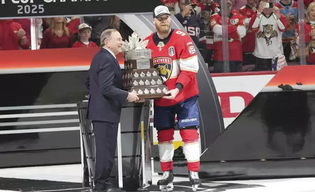 NHL commissioner Gary Bettman presents the Conn Smythe Trophy to Sam Bennett after defeating the Edmonton Oilers in Game 6 of the NHL hockey Stanley Cup Final Tuesday, June 17, 2025, in Sunrise, Fla. (AP Photo/Lynne Sladky)