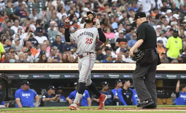 Minnesota Twins' Byron Buxton (25) reacts after hitting a home run as home plate Todd Tichenor, right, looks on during the fifth inning of a baseball game against the Detroit Tigers, Friday, June 27, 2025, in Detroit. (AP Photo/Jose Juarez)