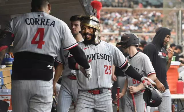 Minnesota Twins' Byron Buxton (25) is congratulated by Carlos Correa (4) after hitting a home run during the fifth inning of a baseball game against the Detroit Tigers, Friday, June 27, 2025, in Detroit. (AP Photo/Jose Juarez)