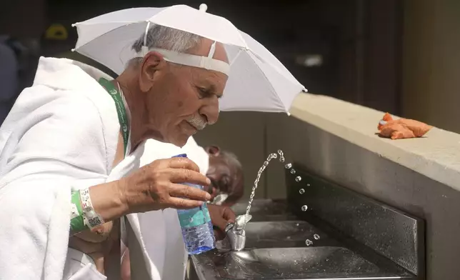 A Muslim pilgrim drinks water as he arrives to attend the symbolic stoning of the devil, the last rite of the annual Hajj, in Mina near the holy city of Mecca, Saudi Arabia, Friday, June 6, 2025. (AP Photo/Amr Nabil)