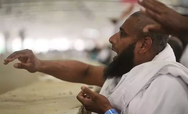 A Muslim pilgrim casts stones at pillars in the symbolic stoning of the devil, the last rite of the annual Hajj, in Mina near the holy city of Mecca, Saudi Arabia, Friday, June 6, 2025. (AP Photo/Amr Nabil)