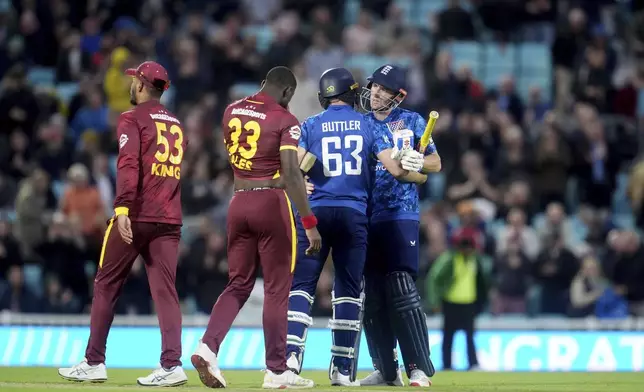 England's Jos Buttler, second right, and Harry Brook, right, after the winning runs during the third One Day International cricket match between West Indies and England at Oval, London, Tuesday June 3, 2025. (Adam Davy/PA via AP)
