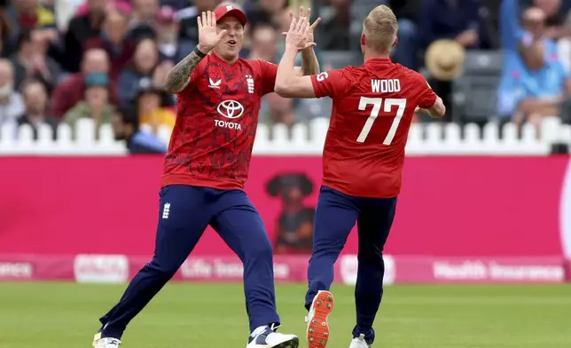 England's Luke Wood, right, celebrates the wicket of West Indies' Evin Lewis during the second Men's International Twenty20 match at the Seat Unique Stadium, in Bristol, England, Sunday June 8, 2025. (Nigel French/PA via AP)