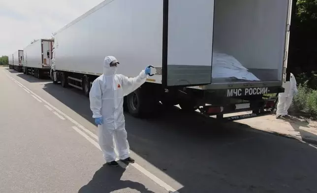 In this photo, taken from video distributed by Russian Defense Ministry Press Service on Sunday, June 8, 2025, orderlies shows an open refrigerator of the first convoy, carrying bodies of Ukrainian soldiers for repatriation, at an exchange area near Novaya Guta, Belarus, for the beginning of a large-scale exchange between Russia and Ukraine. (Russian Defense Ministry Press Service via AP)