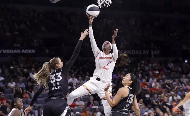 Phoenix Mercury guard Kahleah Copper (2) shoots a layup between Las Vegas Aces center Elizabeth Kitley (33) and guard Aaliyah Nye (13) during the first half of a WNBA basketball game Sunday, June 15, 2025, in Las Vegas. (Steve Marcus/Las Vegas Sun via AP)
