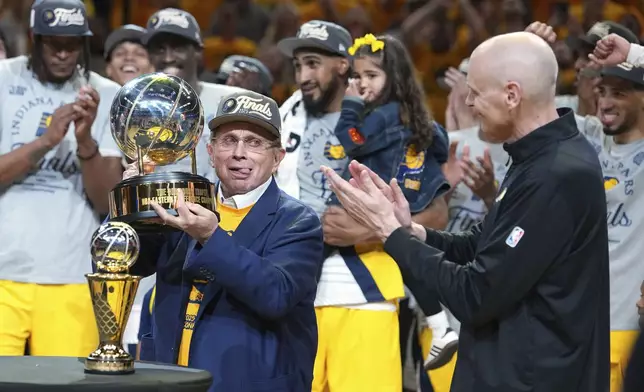Indiana Pacers owner Herb Simon, left, holds the trophy near head coach Rick Carlisle after the Pacers won Game 6 of the Eastern Conference finals of the NBA basketball playoffs against the New York Knicks in Indianapolis, Saturday, May 31, 2025. (AP Photo/Michael Conroy)