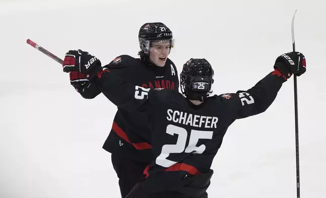 FILE - Canada forward Calum Ritchie, left, celebrates after his goal with defenseman Matthew Schaefer during third-period IIHF World Junior Hockey Championship pretournament action, Dec. 21, 2024, in Ottawa, Ontario. (Adrian Wyld/The Canadian Press via AP, file)
