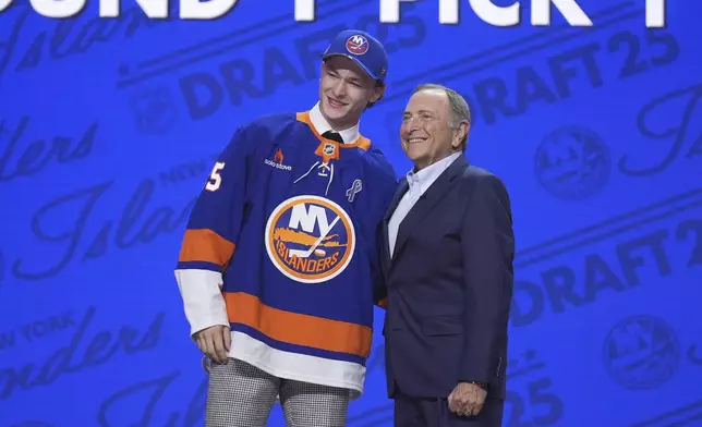 Matthew Schaefer, left, stands with NHL commissioner Gary Bettman after being drafted by the New York Islanders during the NHL hockey draft Friday, June 27, 2025, in Los Angeles. (AP Photo/Damian Dovarganes)