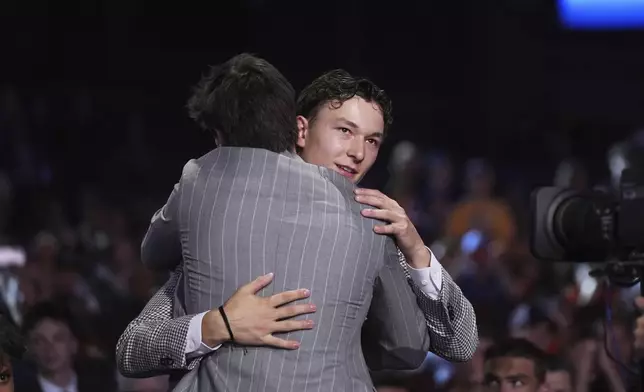 Matthew Schaefer, right, is congratulated after being drafted by the New York Islanders during the NHL hockey draft Friday, June 27, 2025, in Los Angeles. (AP Photo/Damian Dovarganes)