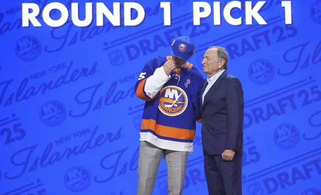 Matthew Schaefer, left, reacts with NHL commissioner Gary Bettman after being drafted by the New York Islanders during the NHL hockey draft Friday, June 27, 2025, in Los Angeles. (AP Photo/Damian Dovarganes)