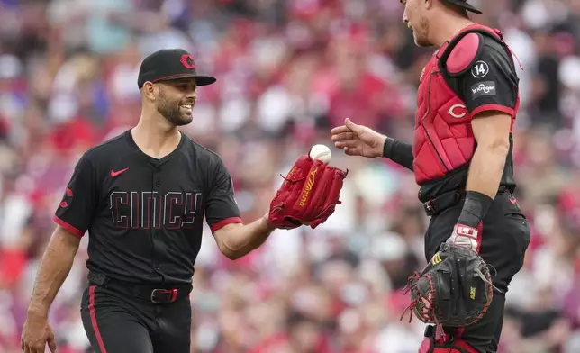 Cincinnati Reds pitcher Nick Martinez, left, speaks with catcher Tyler Stephenson at the pitcher's mound during the third inning of a baseball game against the San Diego Padres, Friday, June 27, 2025, in Cincinnati. (AP Photo/Jeff Dean)