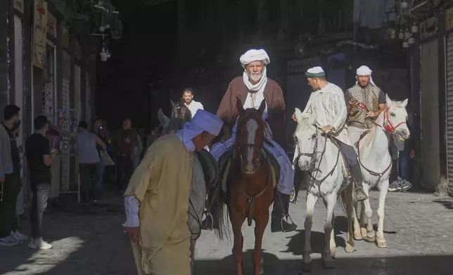 Pilgrims, including three from Spain, ride their horses through the Souq al-Hamidiyah market during their months-long horseback journey from Spain to Saudi Arabia to perform the Hajj, in Damascus, Syria, April 21, 2025. (AP Photo/Omar Albam)