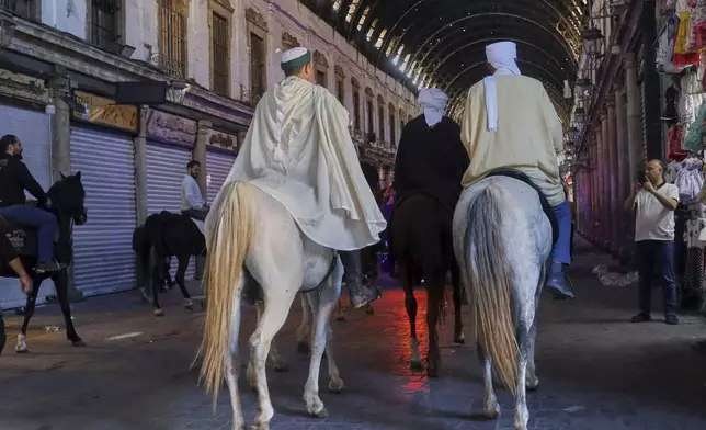 Pilgrims, including three from Spain, ride their horses through the Souq al-Hamidiyah market during their months-long horseback journey from Spain to Saudi Arabia to perform the Hajj, in Damascus, Syria, April 21, 2025. (AP Photo/Omar Albam)